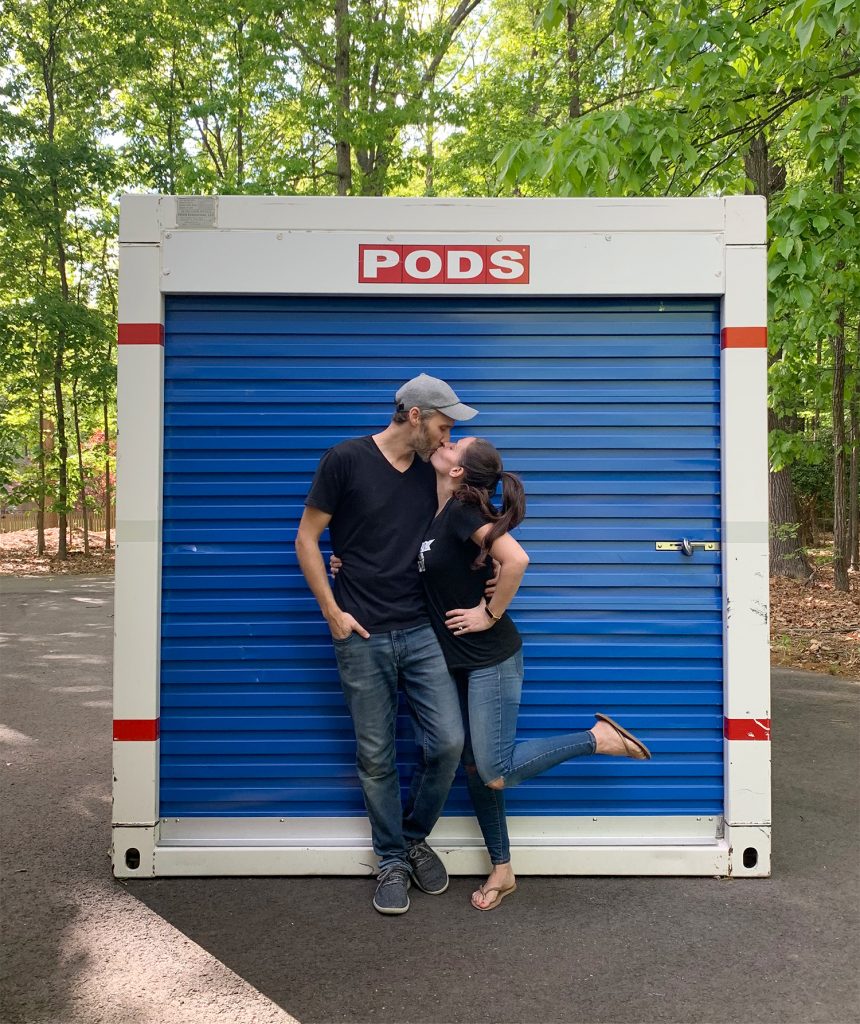 John and Sherry kissing in front of moving PODS storage container