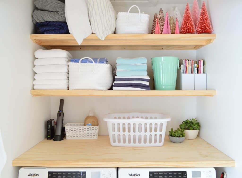 Light wood laundry shelves made from plywood organized with laundry storage