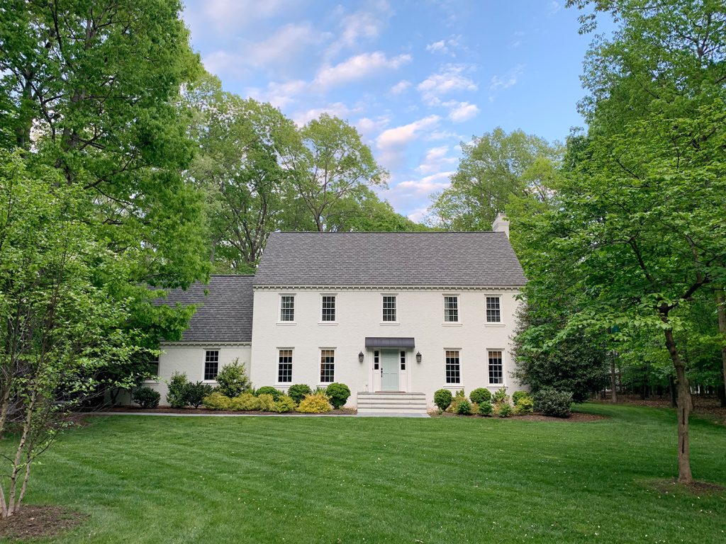 White brick house with large grassy yard